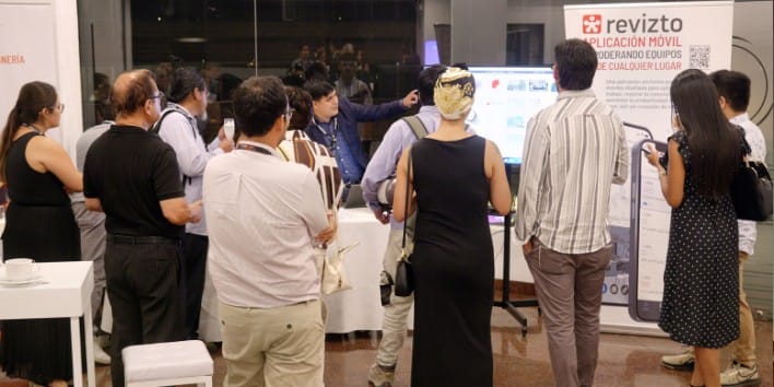 Asistentes al Local Hub Lima conversando entre ellos y mirando material informativo del evento